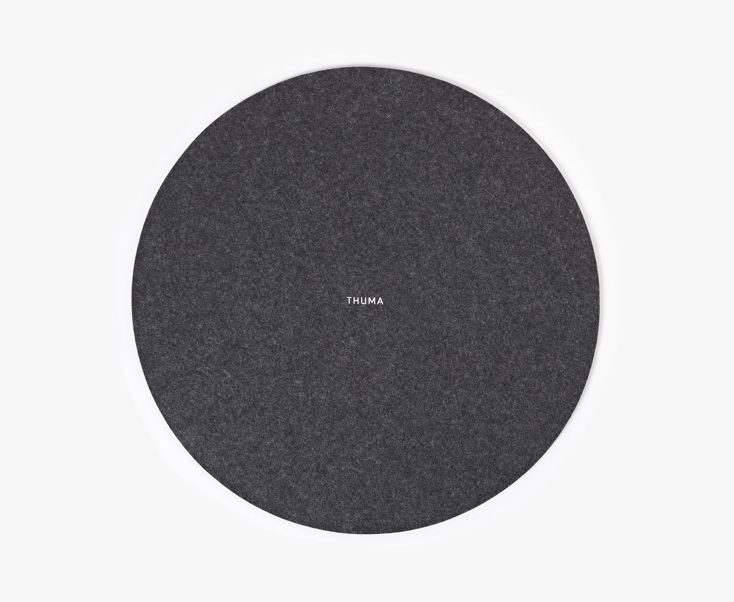 The Felt Tops is a round, dark gray felt mat with THUMA printed in small white letters at the center, displayed on a plain white background.