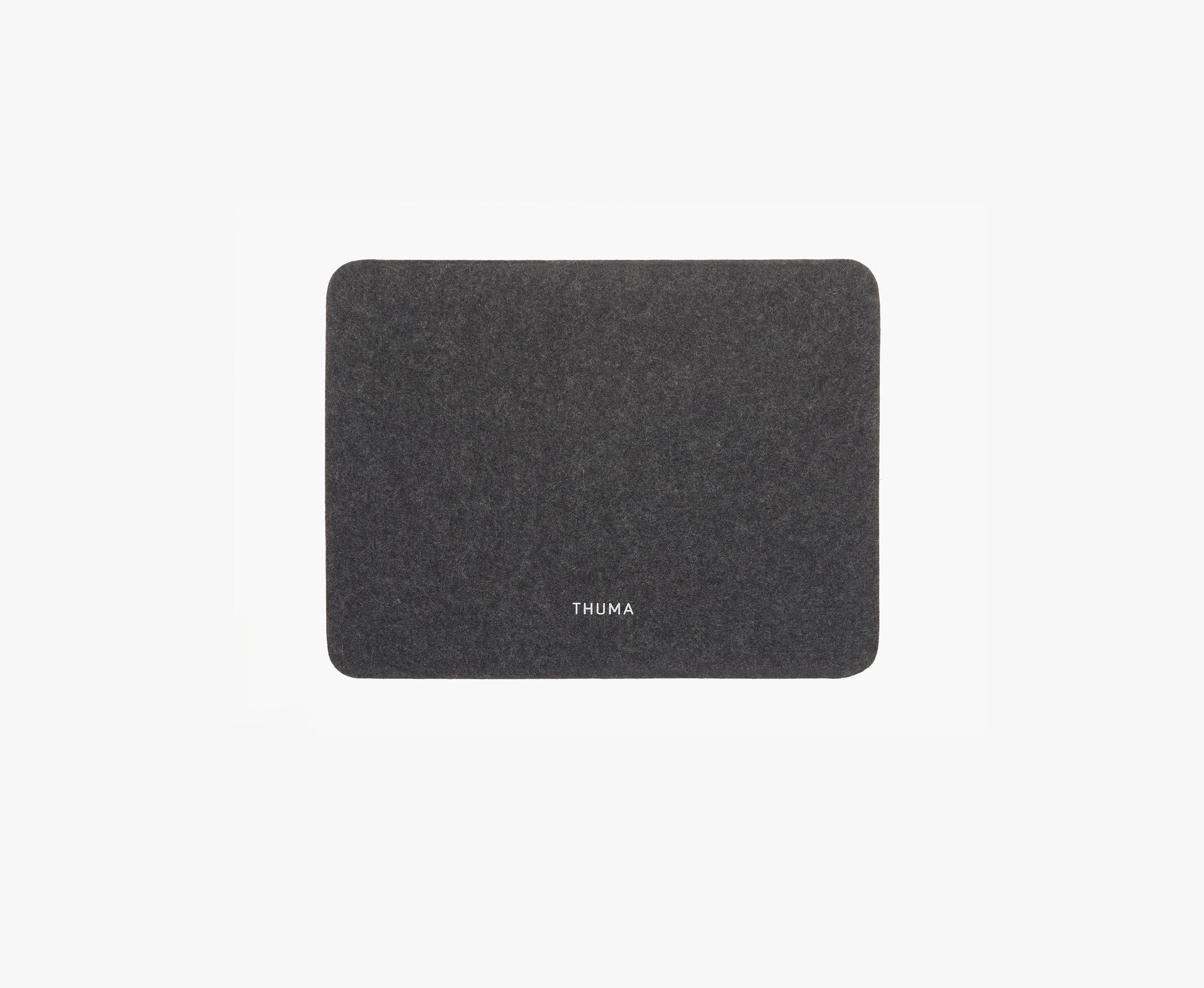 The Felt Tops is a rectangular dark gray felt mat with rounded corners and THUMA in white at the center, shown on a plain white background.