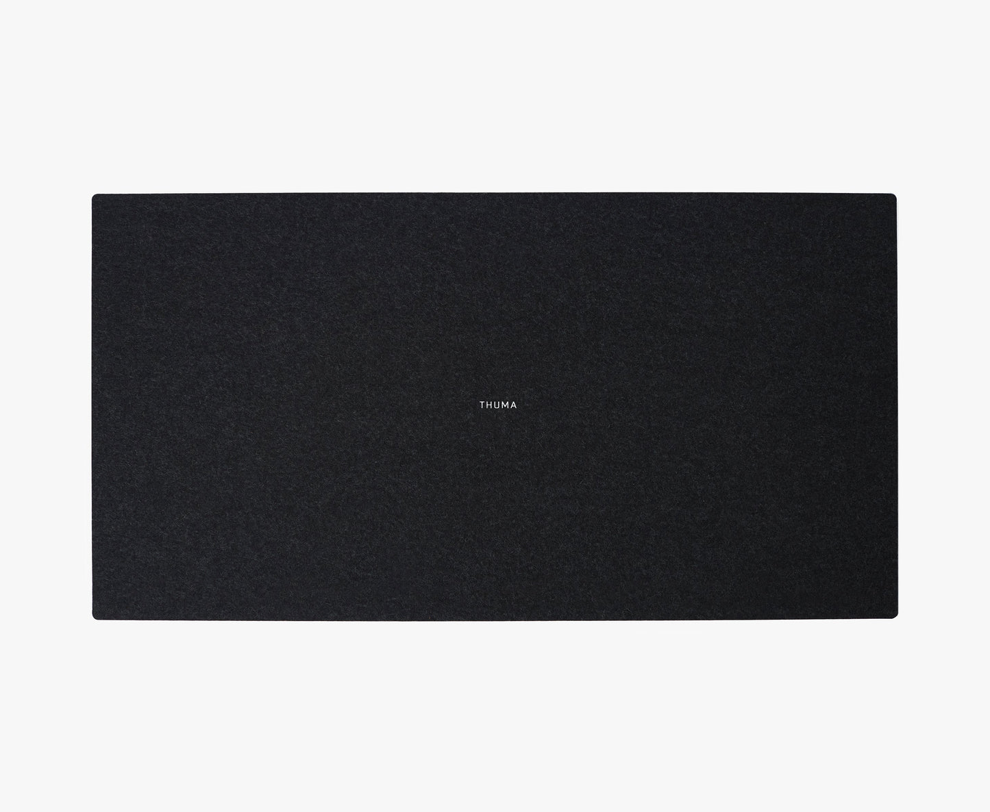 The Felt Tops is a large, rectangular, dark gray mat with a smooth texture and THUMA printed in small white letters at the center, displayed on a white background.