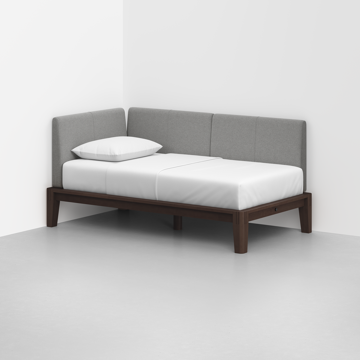 The Classic Daybed features a dark wood frame, white bedding, one pillow, and a light gray upholstered backrest, positioned in the corner of a modern white room.