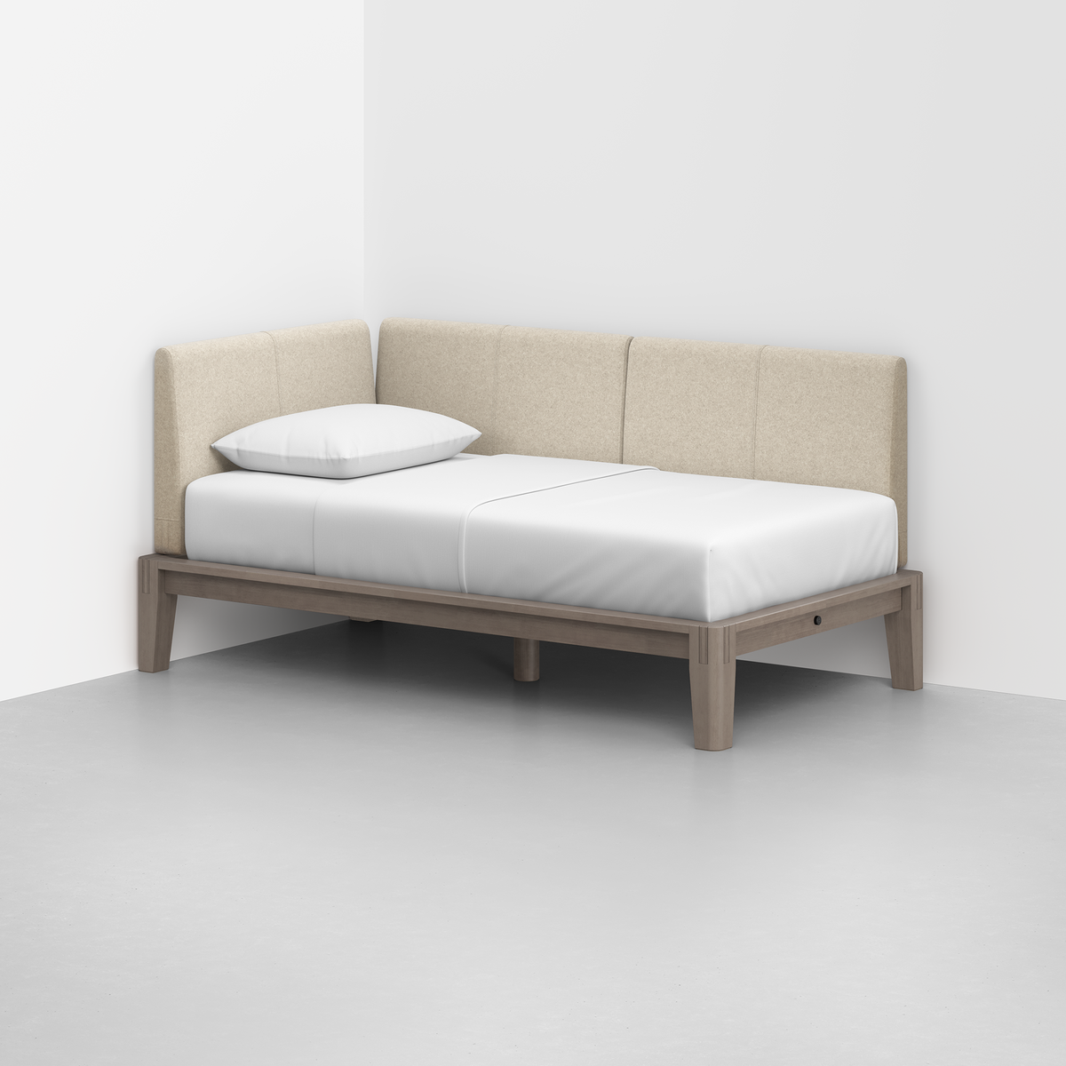The Classic Daybed features light beige upholstered backrests, a single white pillow, and white bedding, situated in a modern room with white walls and a gray floor.