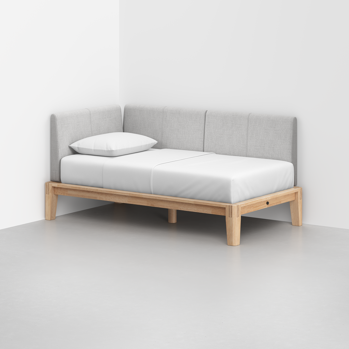 The Classic Daybed features a light wood frame, gray upholstered backrest on two sides, and a white mattress with a single pillow, perfectly suited for bright, open spaces.