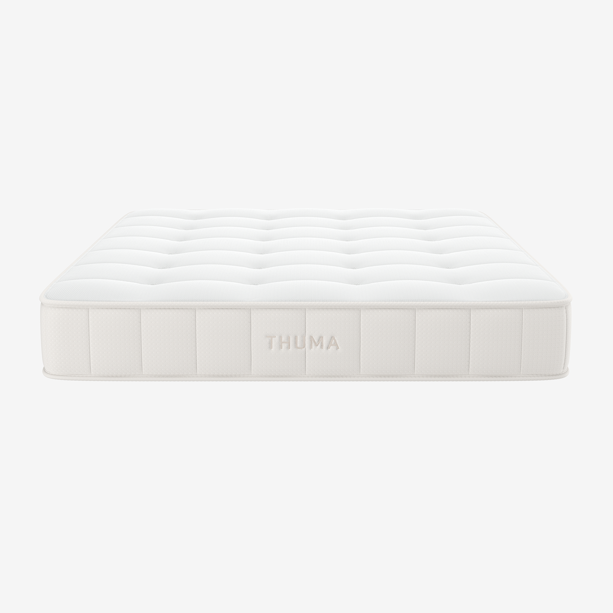A white, rectangular Hybrid Mattress with a quilted top and the brand name THUMA embroidered on the side, displayed against a plain light background.