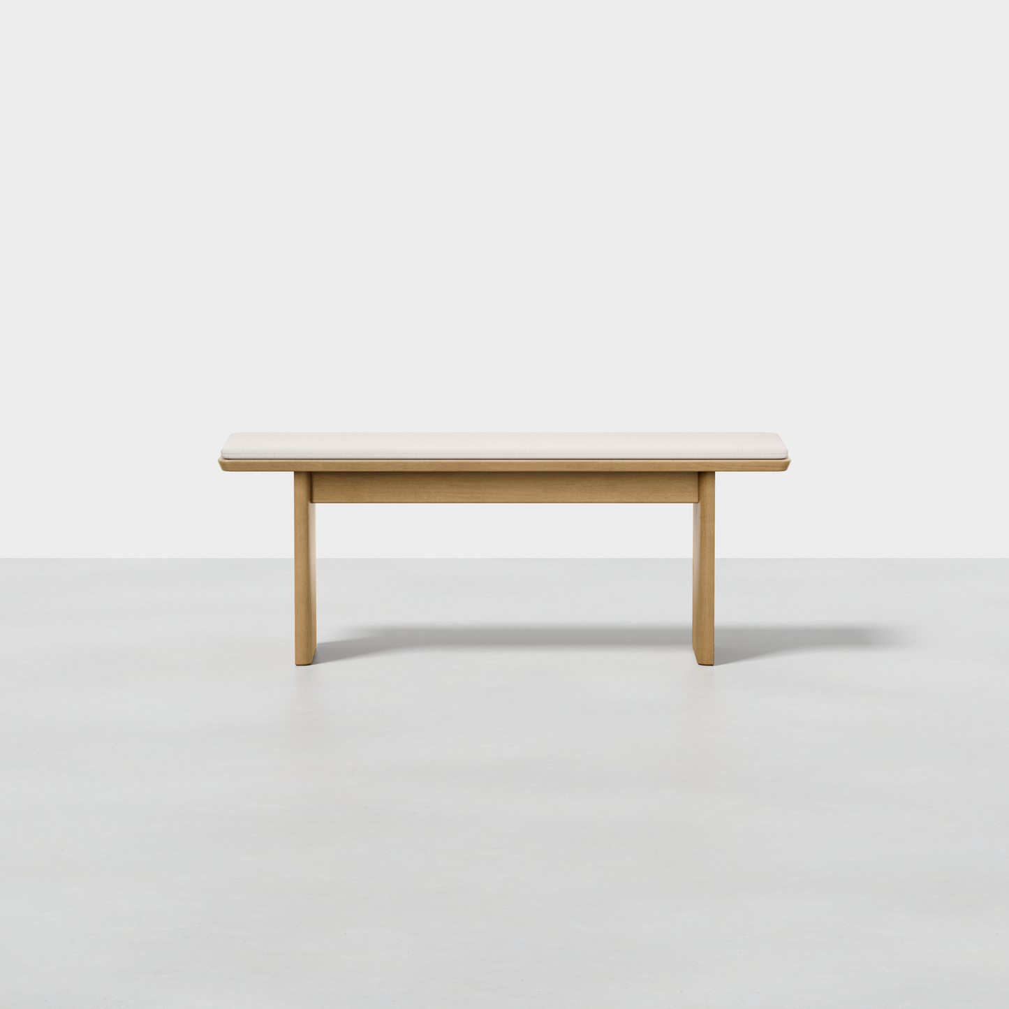The Pillar Bench features a simple, modern design with clean lines and a light wood finish, shown against a plain white background on a light gray floor.