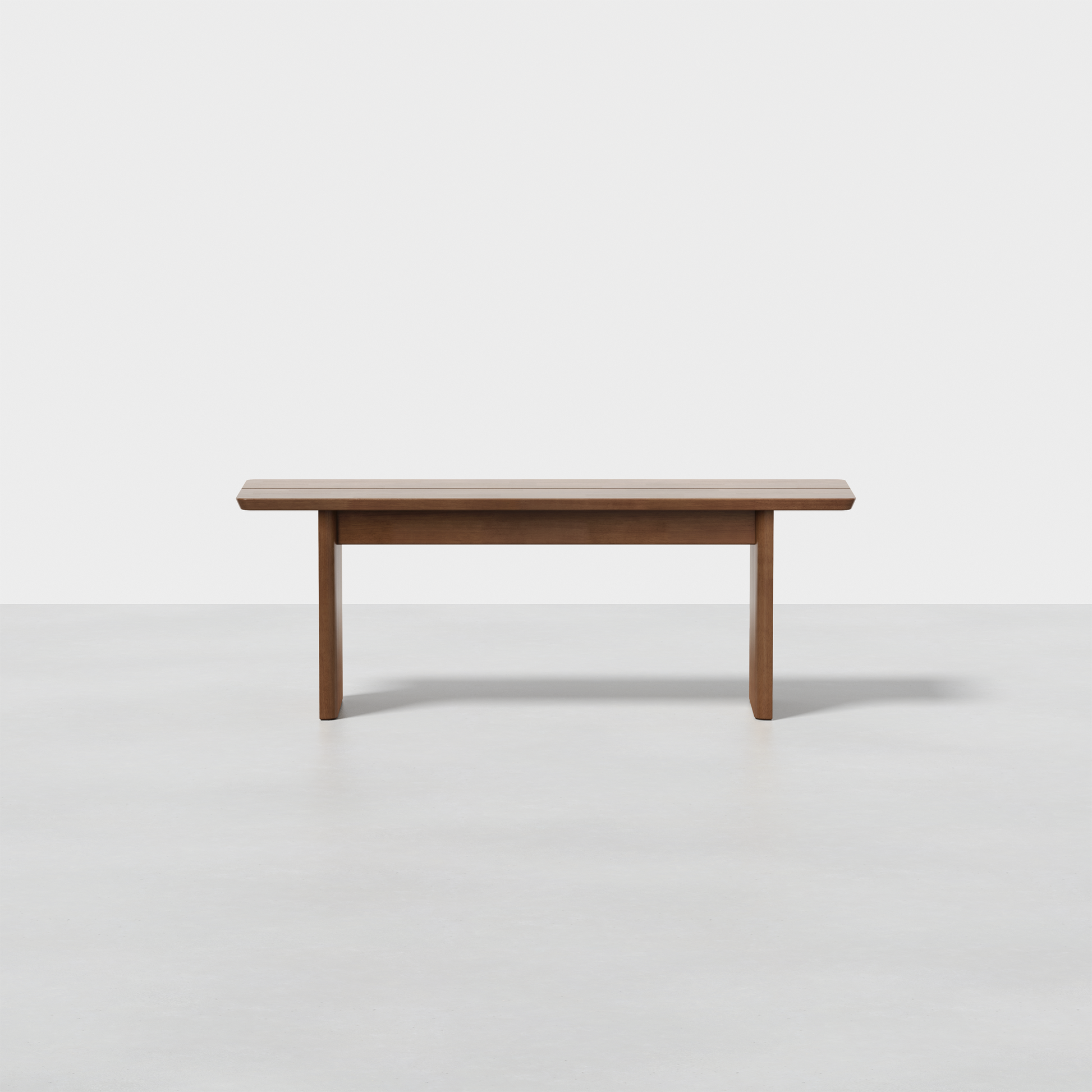 The Pillar Bench is a modern wooden bench featuring clean lines, a rectangular seat, and three sturdy legs, shown against a plain white background.