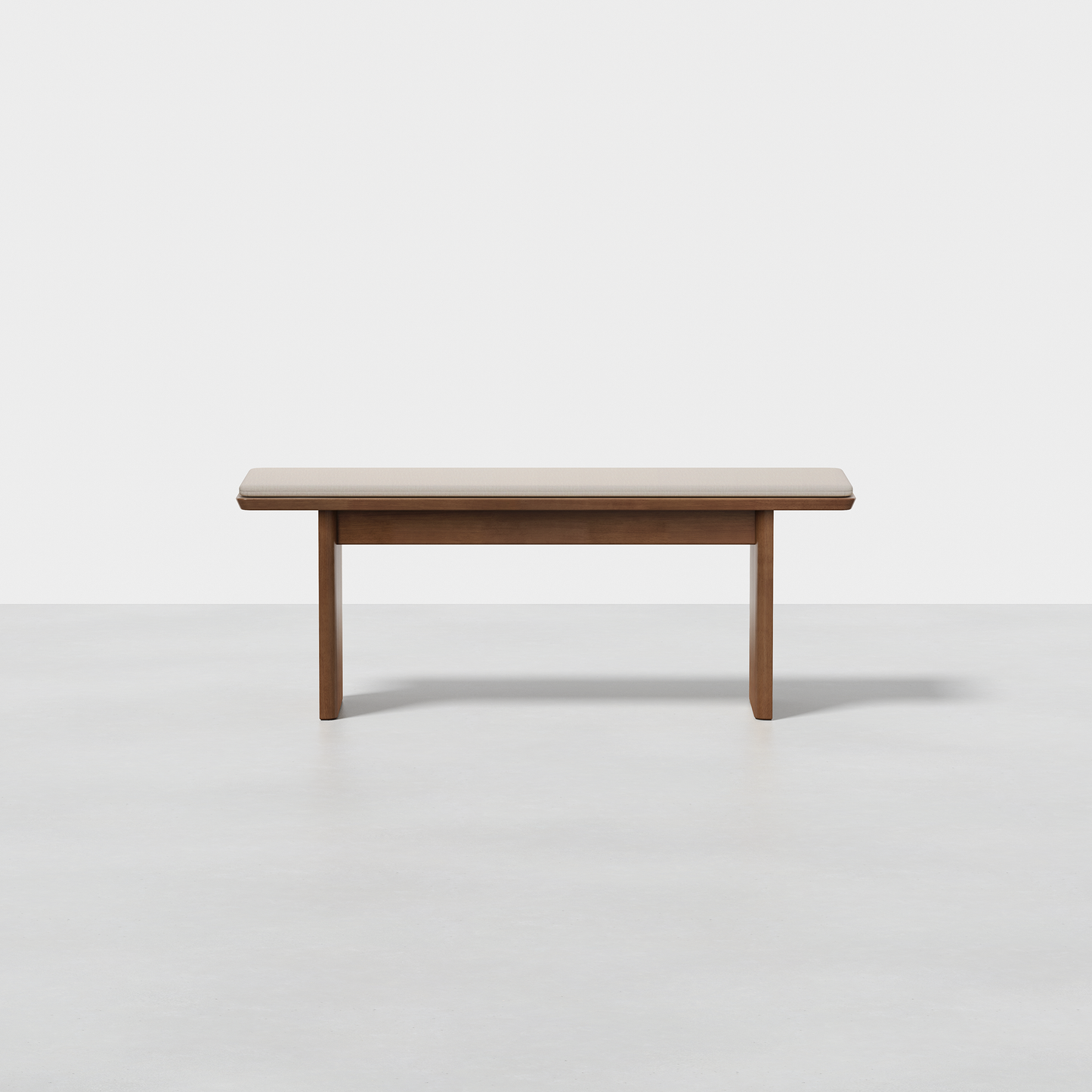 The Pillar Bench features a flat wooden seat and four straight legs, shown on a light gray floor with a plain white backdrop.