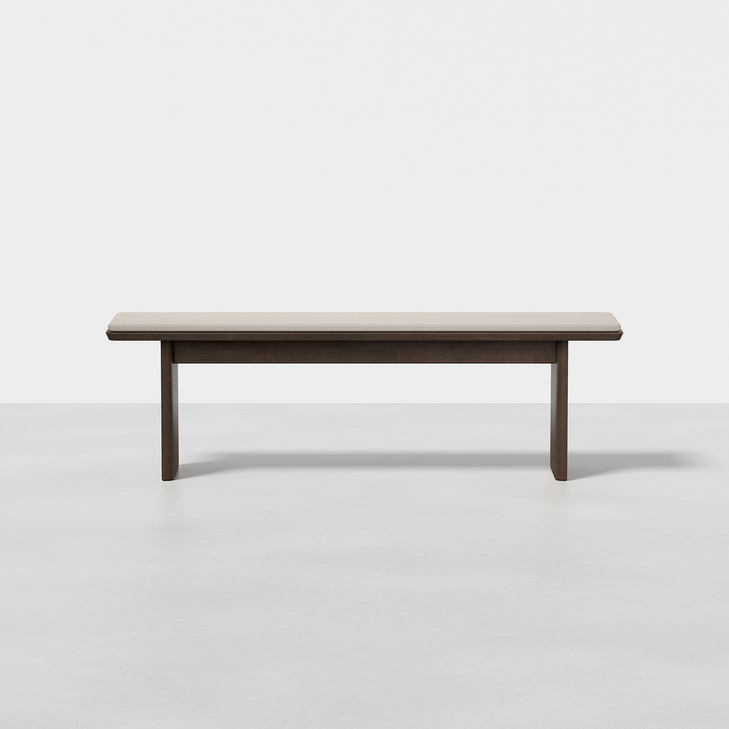 The Pillar Bench is a minimalist, rectangular wooden bench featuring clean lines and a dark finish, shown on a smooth light-colored floor against a plain white background.