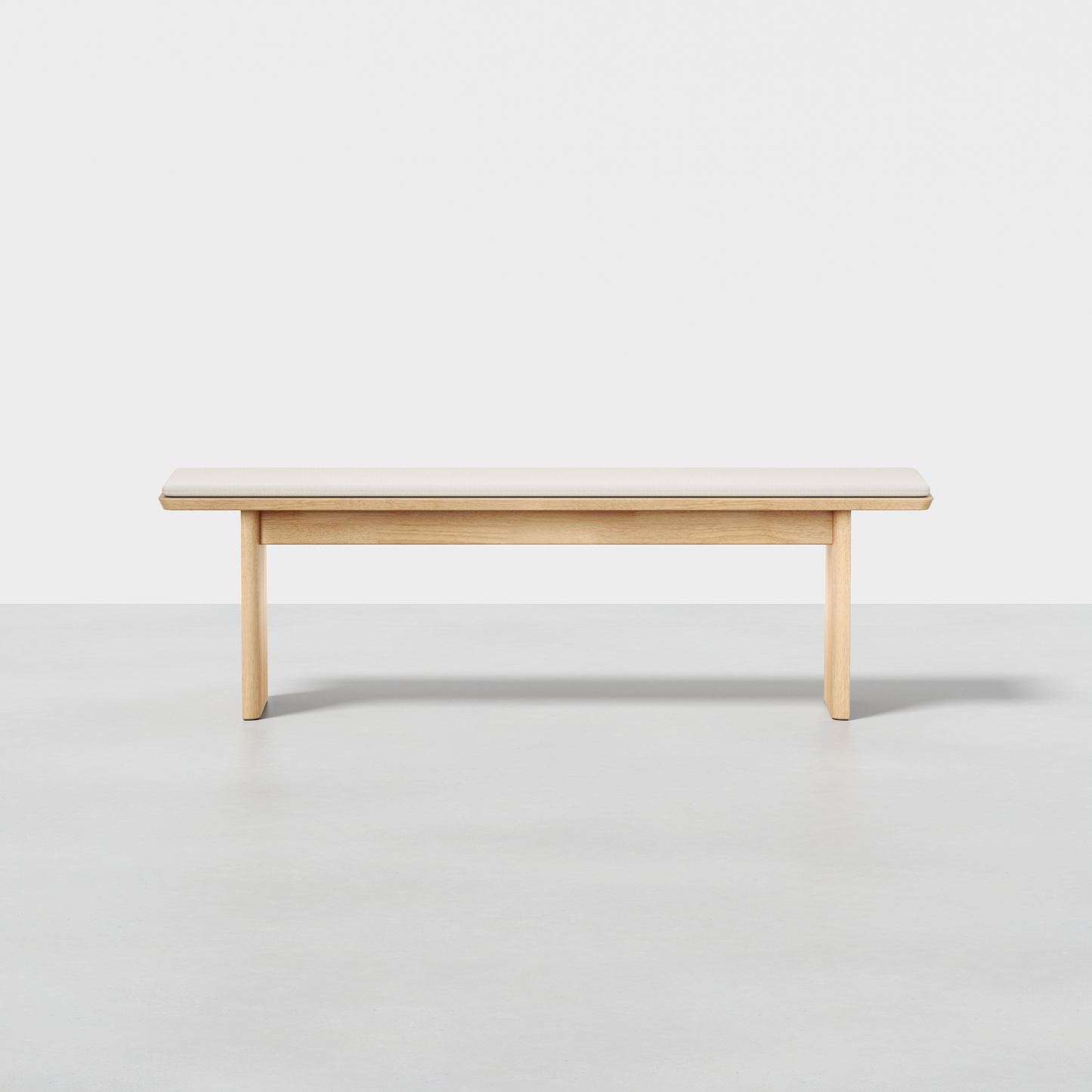 The Pillar Bench features a minimalist wooden design with a light finish, a rectangular seat, and straight legs, shown on a smooth light gray floor against a plain white background.
