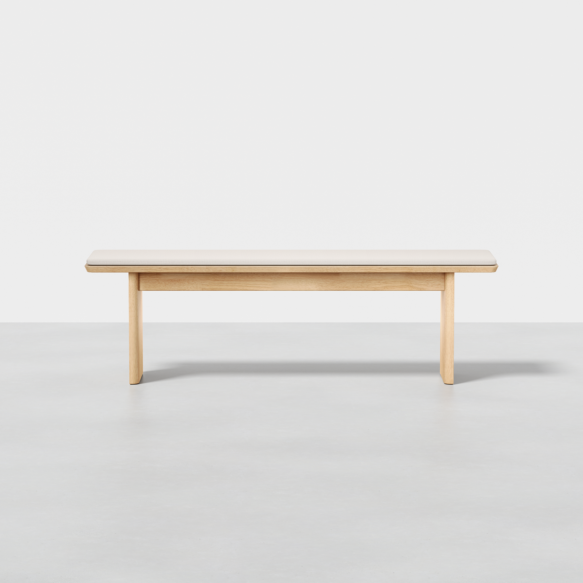 The Pillar Bench features a minimalist wooden design with a light finish, a rectangular seat, and straight legs, shown on a smooth light gray floor against a plain white background.