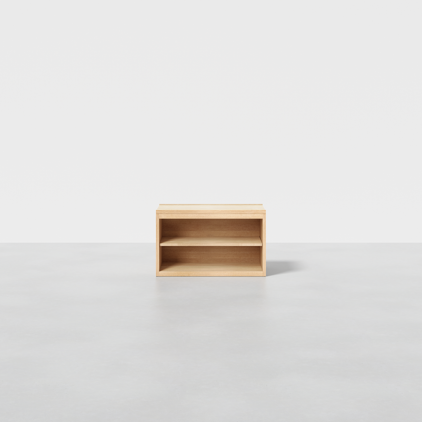 The Nest Nightstand Open is a small, lightweight wooden shelf with one horizontal divider, shown on a plain grey floor against a white background.