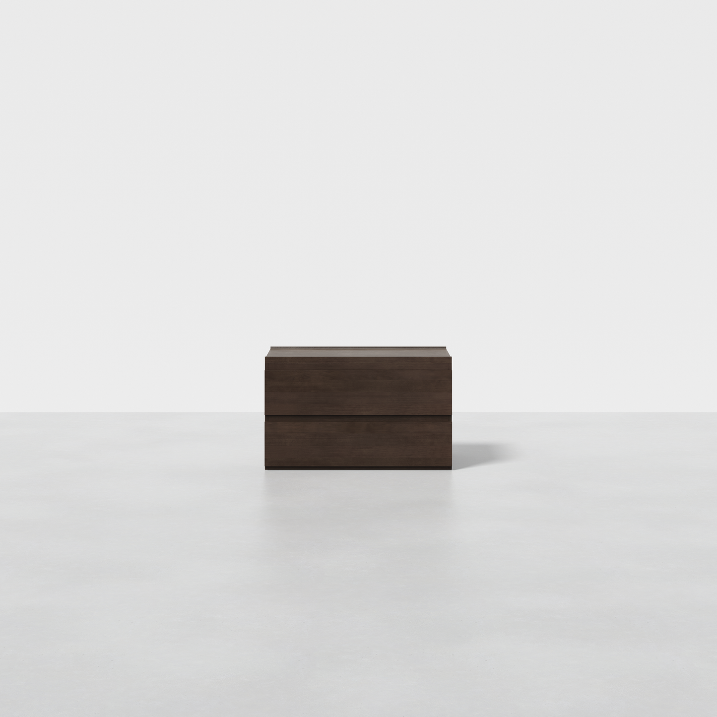 The Nest Nightstand is a dark wooden rectangular piece featuring two horizontal lines, displayed on a light grey surface with a plain white background.