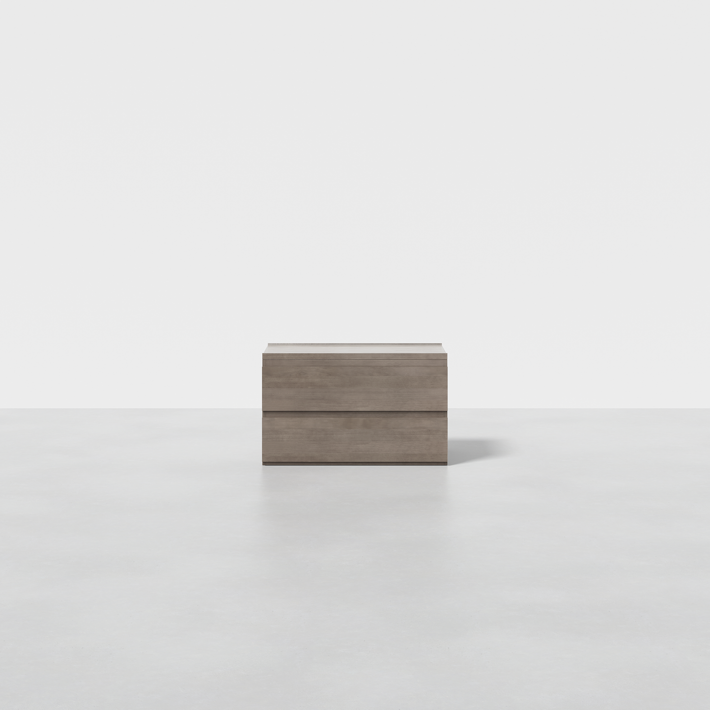 The Nest Nightstand, a minimalist wooden piece with two drawers, stands on a smooth, light gray floor against a plain white background.
